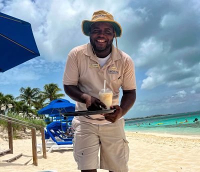 Man smiling and serving drinks on the beach