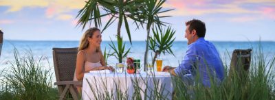 Couple dining outside at Bungalows at Windsong on the Reef